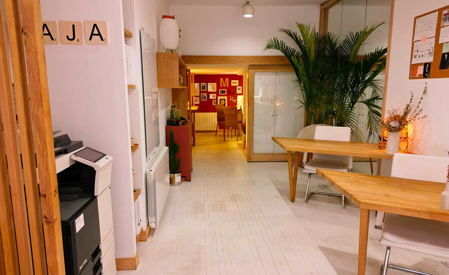 Agence immobilière avec bureaux, chaises, imprimante et décorations au mur